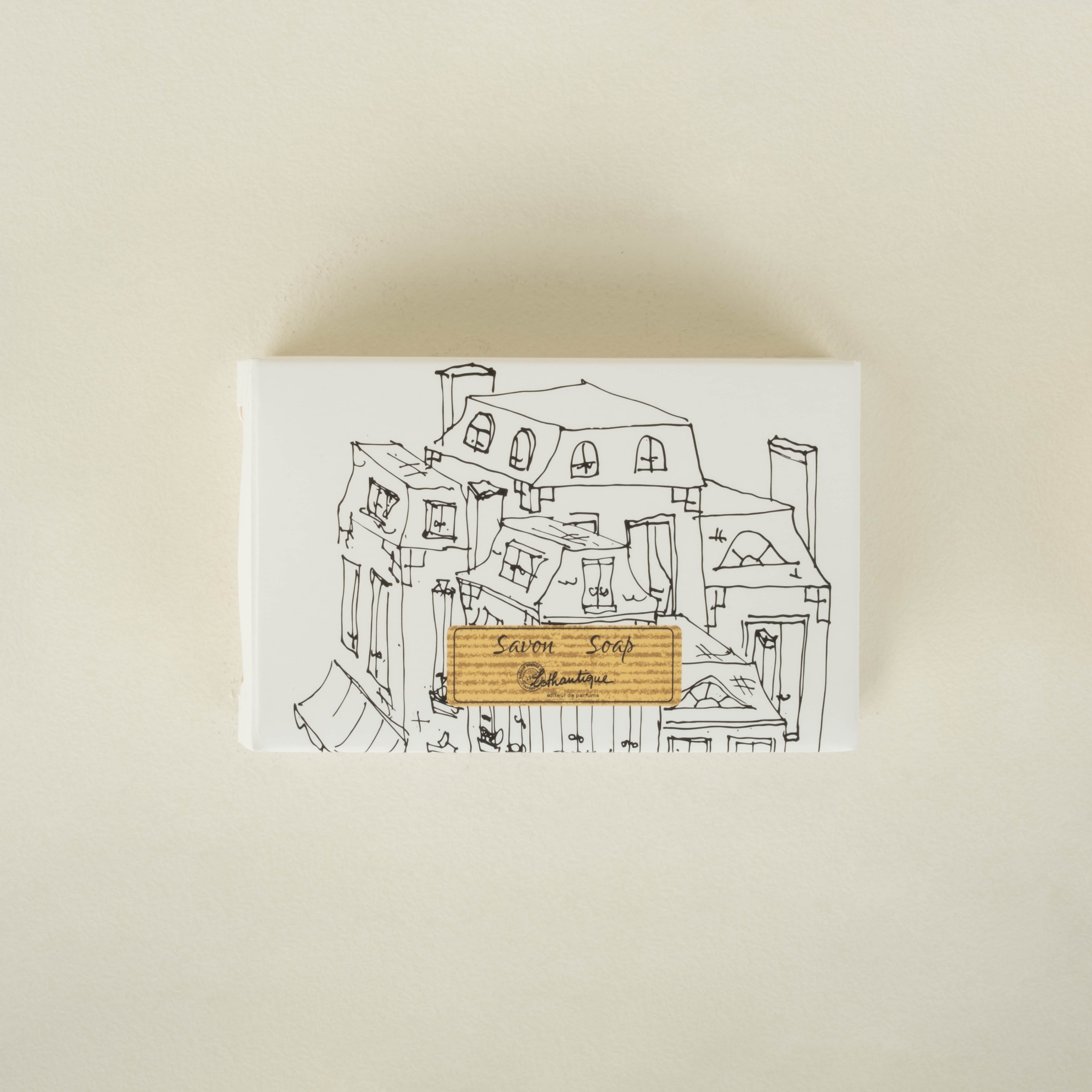 Soap box with a house illustration on the cover against a beige background