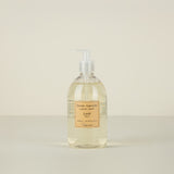 Bottle of liquid soap with a label on a beige background