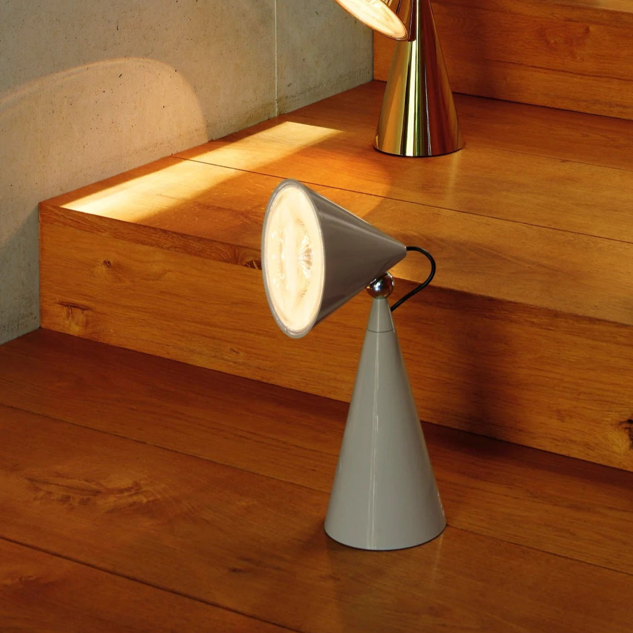 Modern table lamps on a wooden surface with a concrete wall background