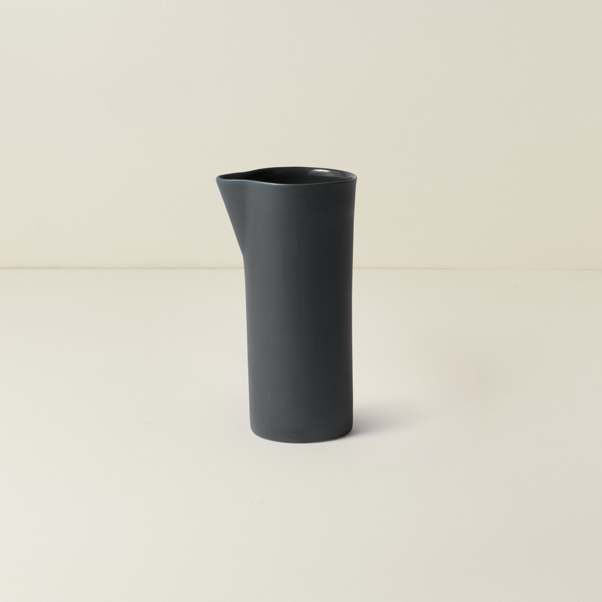 Dark gray ceramic vase on a beige background