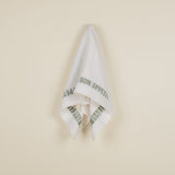 A white linen tea towel with the text 'BON APPETIT' printed in green.