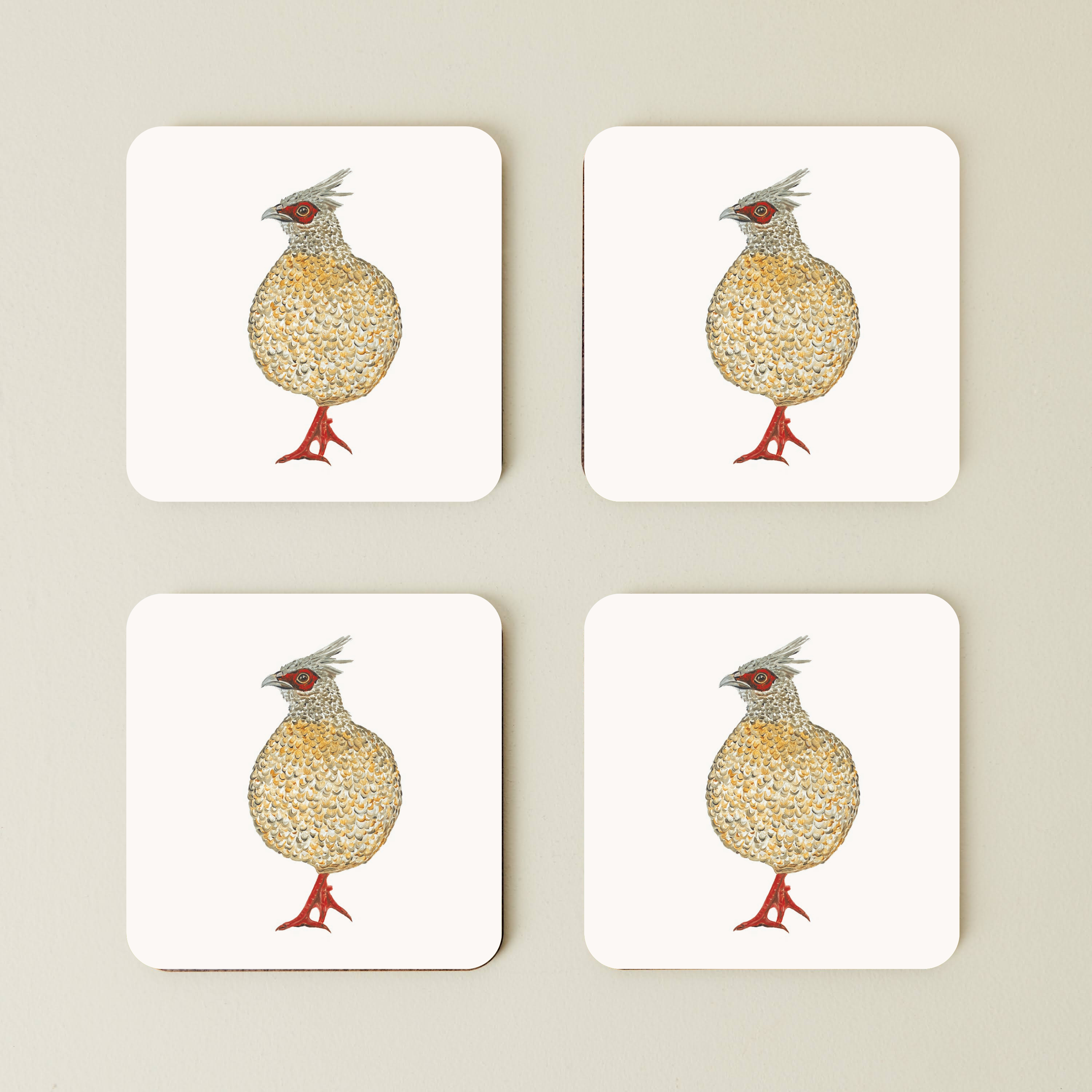 Four coasters with a partridge design on a beige background