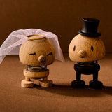 Wooden figurines of a bride and groom on a brown background