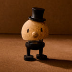 Wooden figurine with a top hat on a brown background