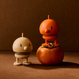 Two small robot-like figures made from pumpkins on a brown background