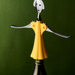 Yellow bottle opener shaped like a person on a wine bottle against a green background
