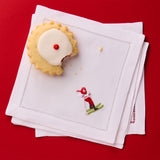Stack of white napkins with embroidered design on a red background