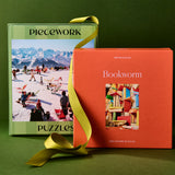 Two puzzle boxes, one green and one orange, with a yellow ribbon on a green background.