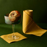 Cocktail glass with a decorative element on a green background and yellow napkin