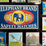 Collection of matchboxes with various designs and an Elephant Brand safety matches sign.