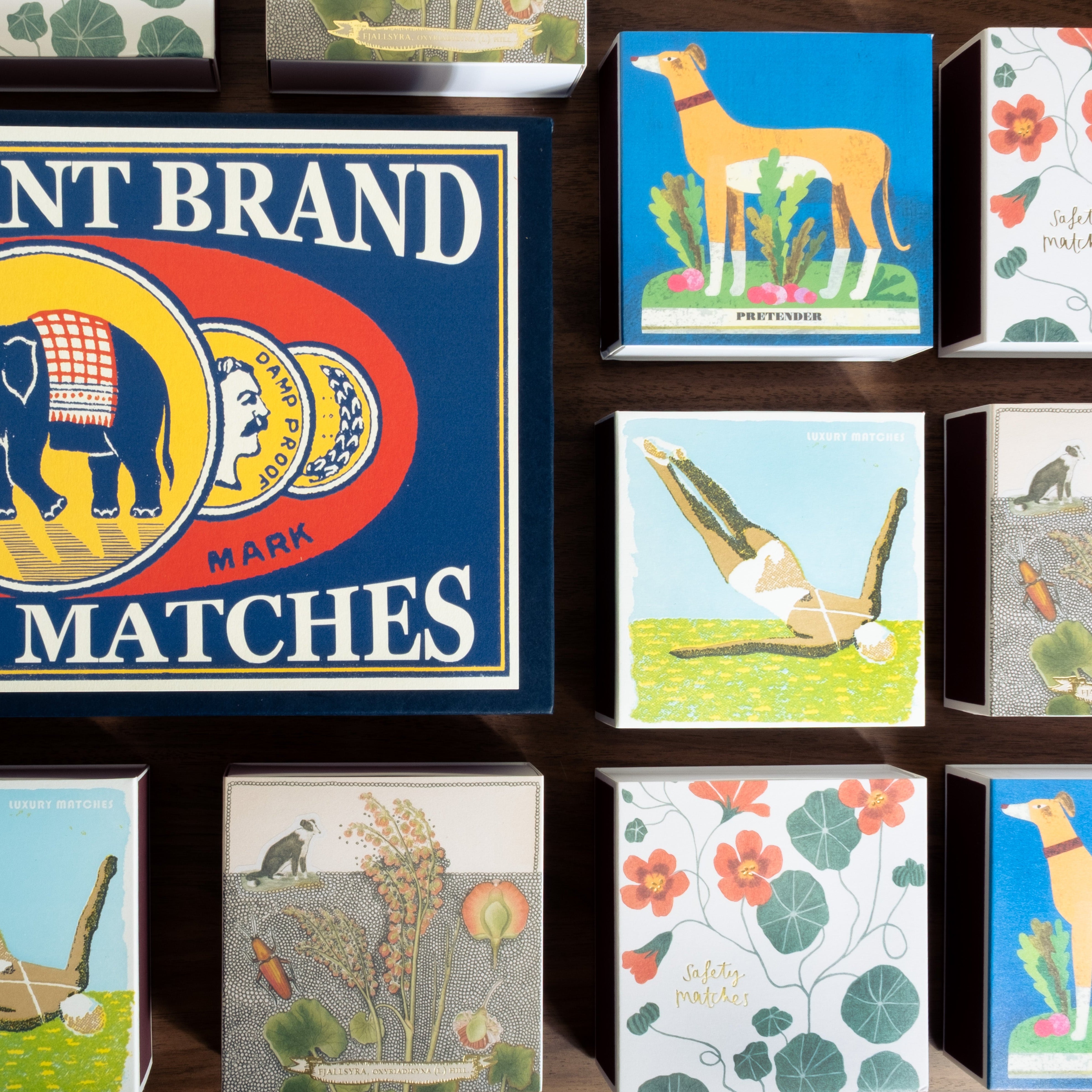 Collection of matchboxes with various designs and an Elephant Brand safety matches sign.