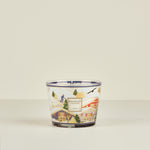 Decorative candle with a scenic design on a beige background