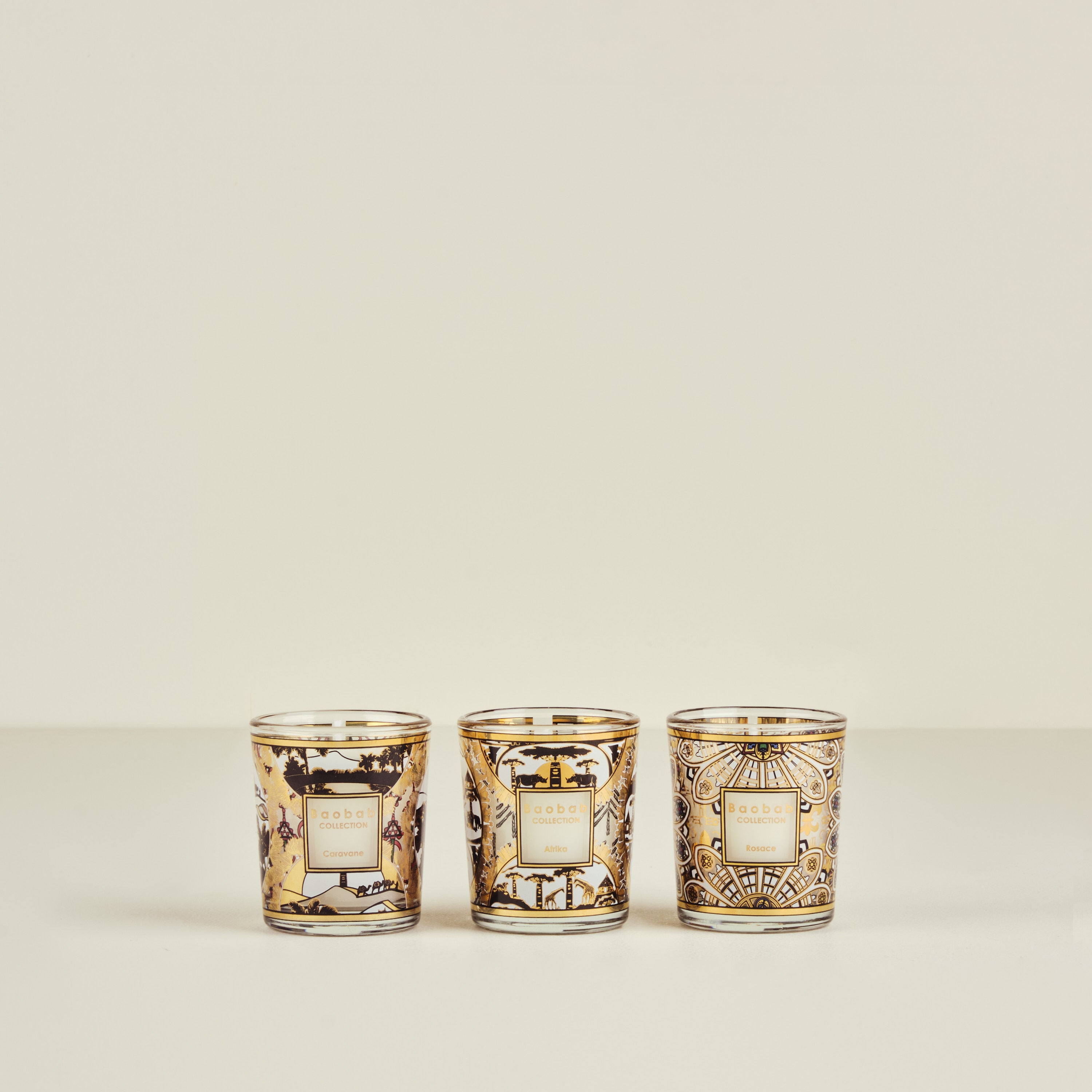 Three decorative candles with intricate designs on a beige background