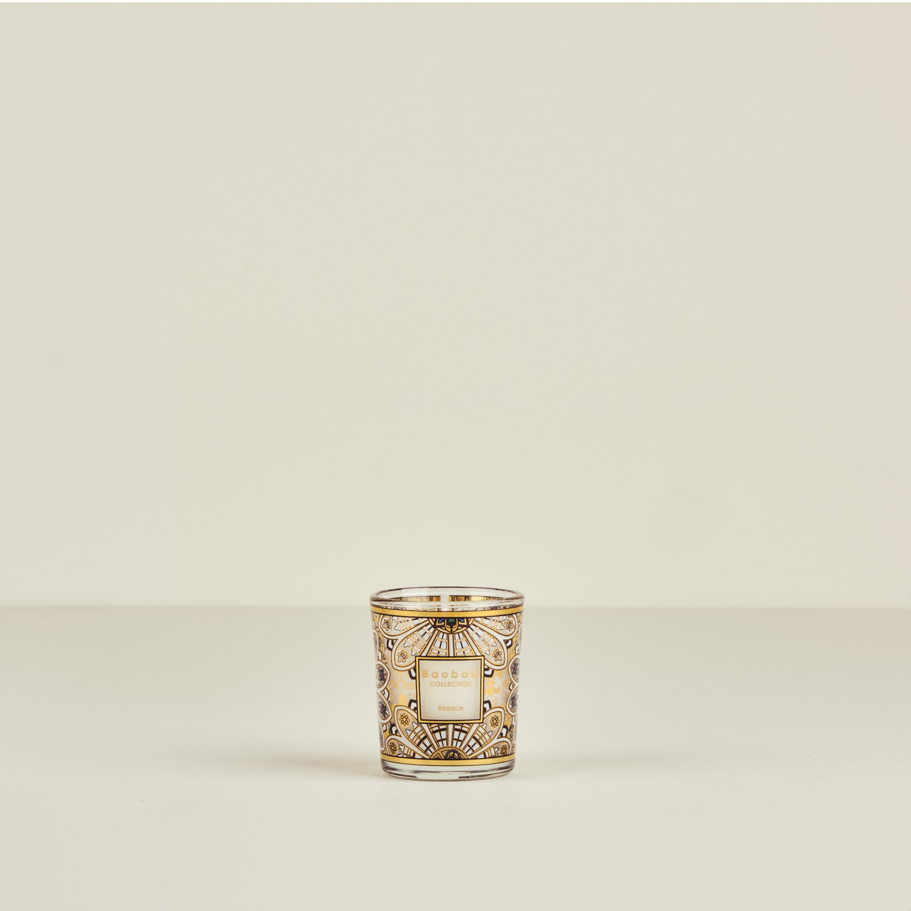 Decorative candle in a glass holder on a beige background