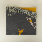 Folded blanker with monkey and giraffe designs on a neutral background