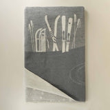 Gray blanket with white ski patterns on a beige background