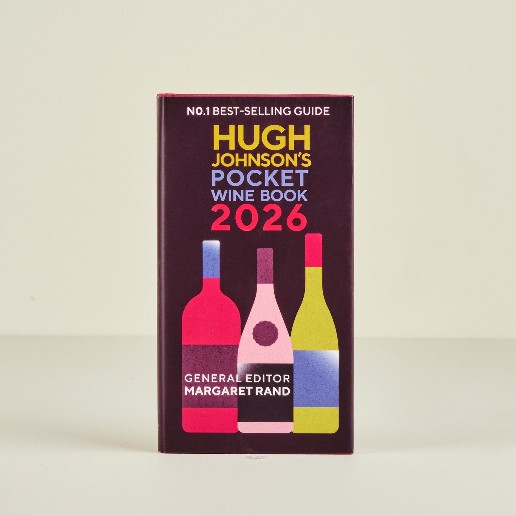 Book titled 'Hugh Johnson's Pocket Wine Book 2026' with colorful wine bottle illustrations on a beige background