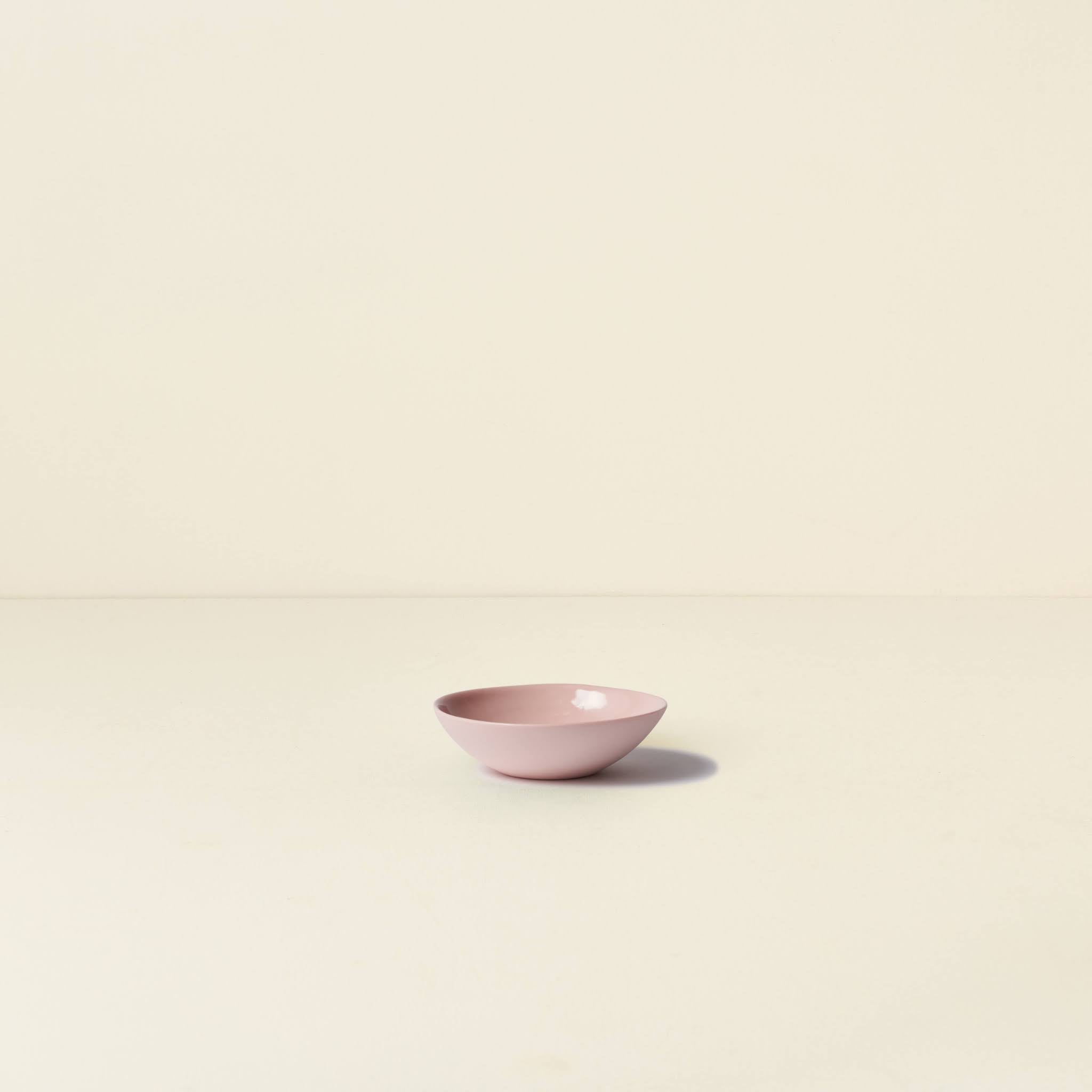 Pink ceramic bowl on a beige background