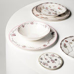 Set of ceramic dishes with floral patterns on a white surface