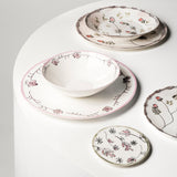 Set of ceramic dishes with floral patterns on a white surface