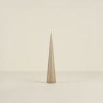 Tapered beige candle on a beige background