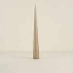 Tapered beige candle on a light beige background