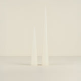 Two white candles on a light beige background