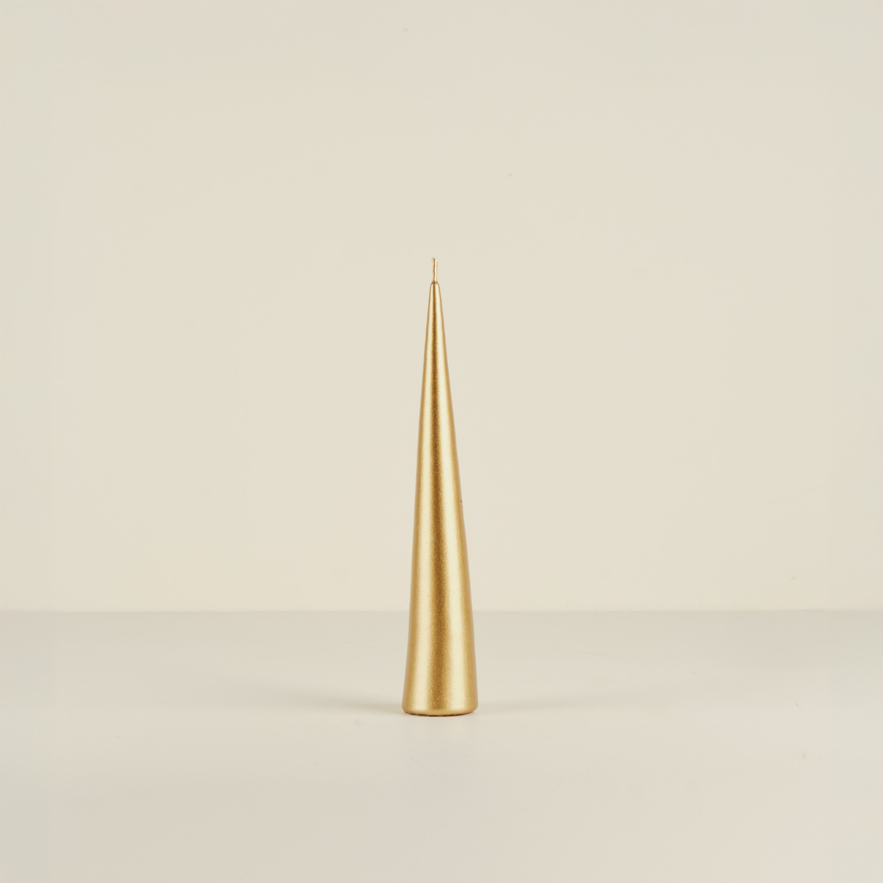 Gold candle on a beige background