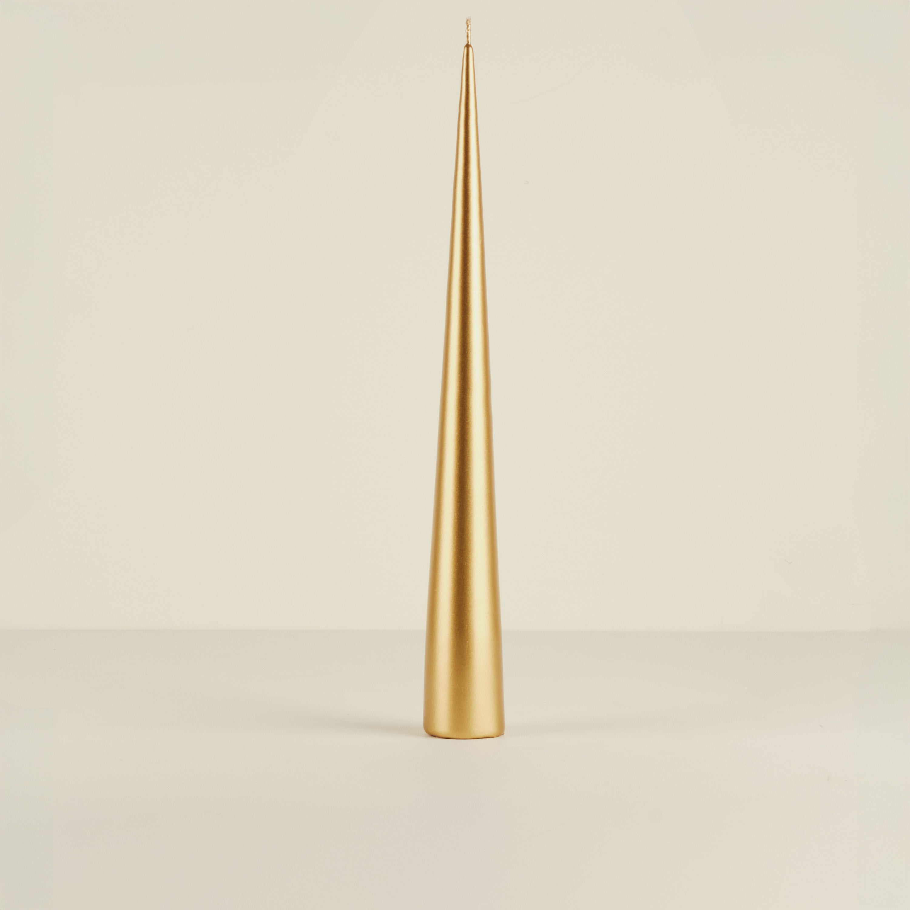 Gold candle on a beige background