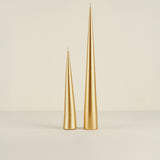 Two gold taper candles on a beige background