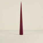 Maroon cone-shaped candle on a beige background
