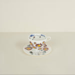 Floral teacup and saucer on a light beige background