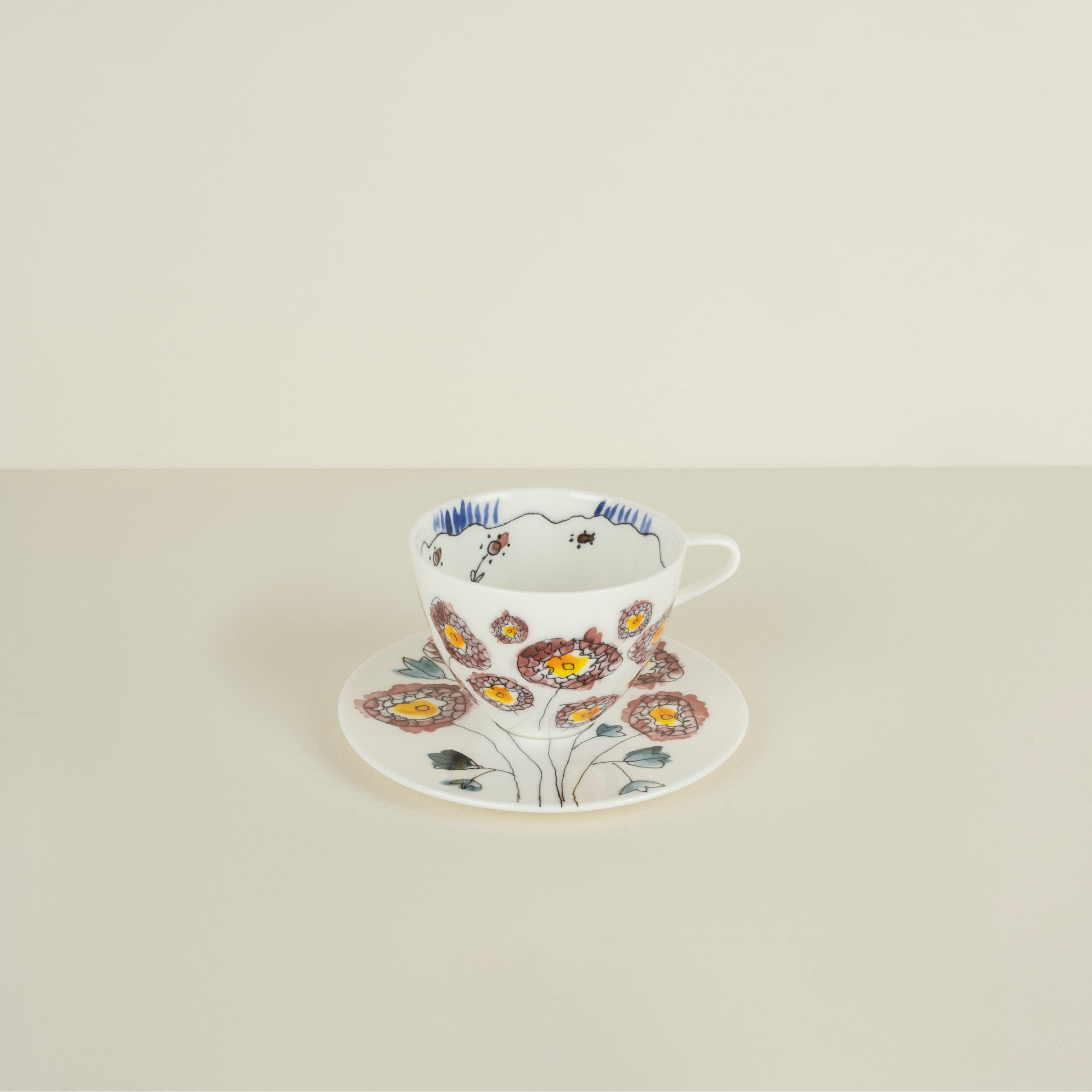 Floral teacup and saucer on a light beige background