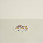 Small round plate with floral design on a beige background