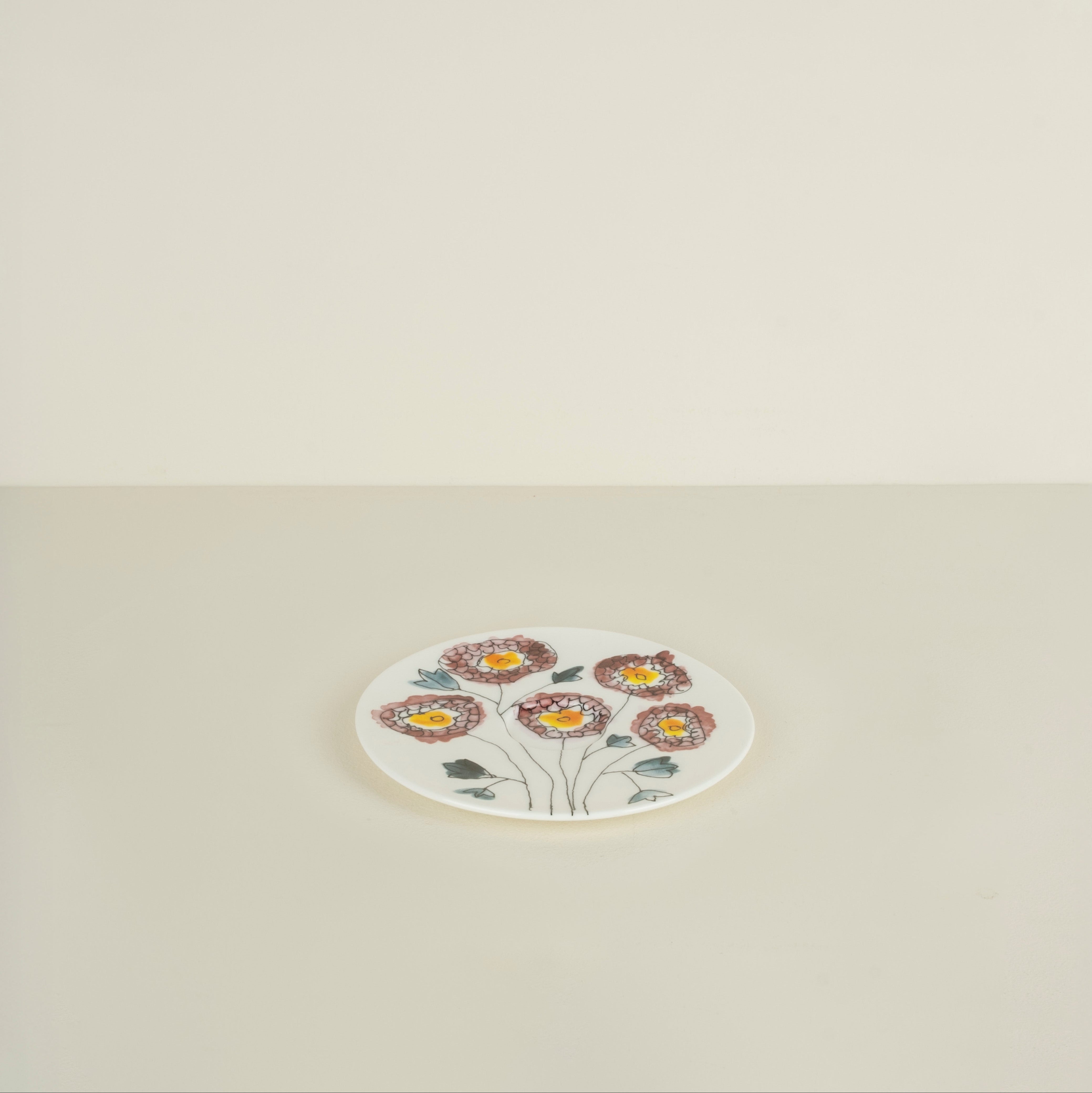 Small round plate with floral design on a beige background