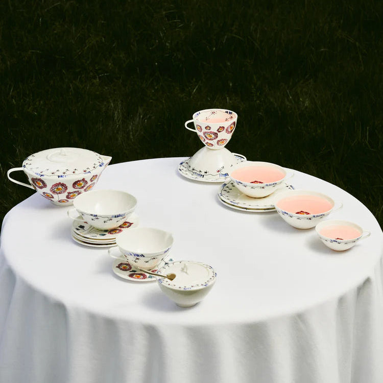 Tea set on a white tablecloth with a dark background