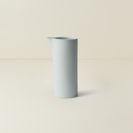 Light blue ceramic vase on a beige background