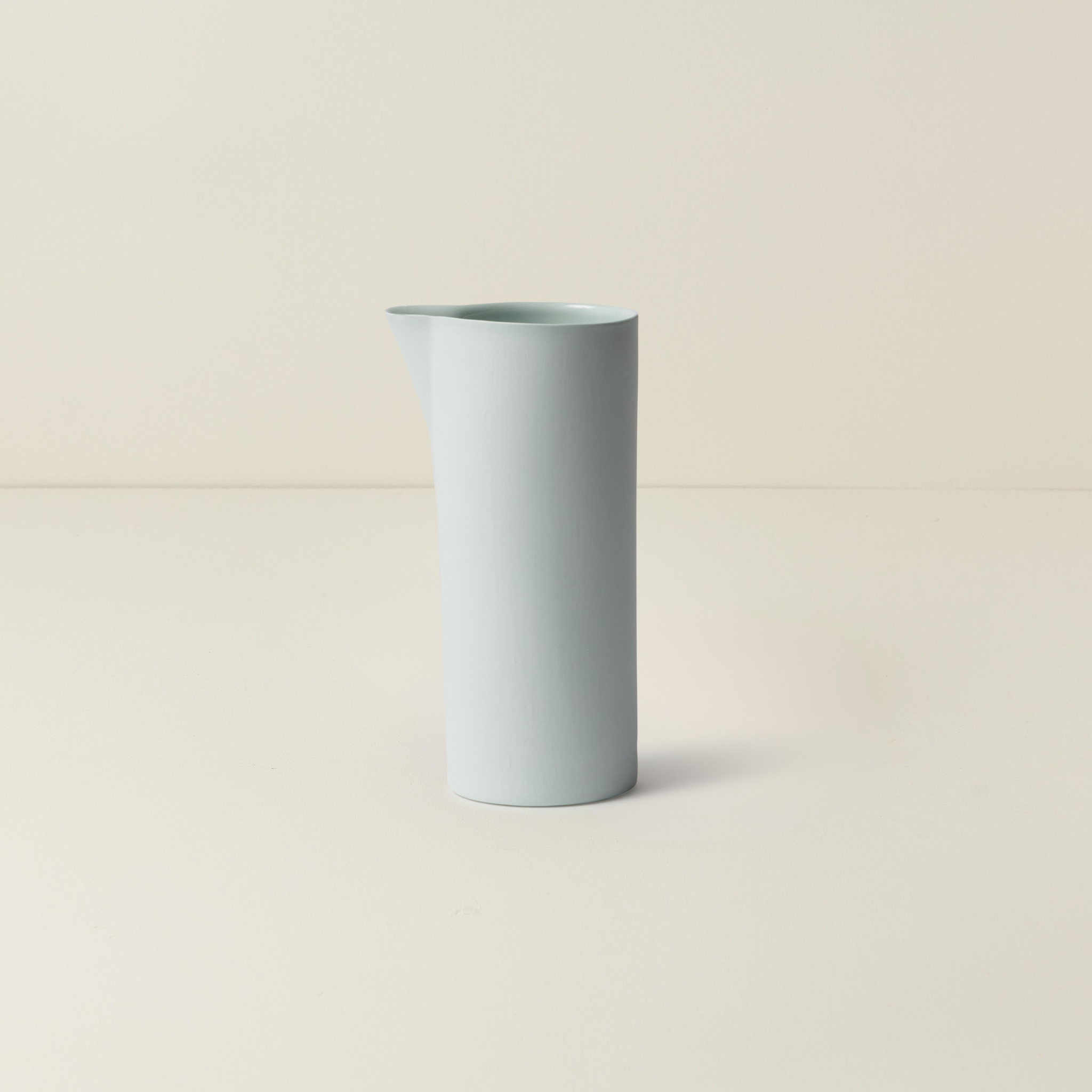 Light blue ceramic vase on a beige background