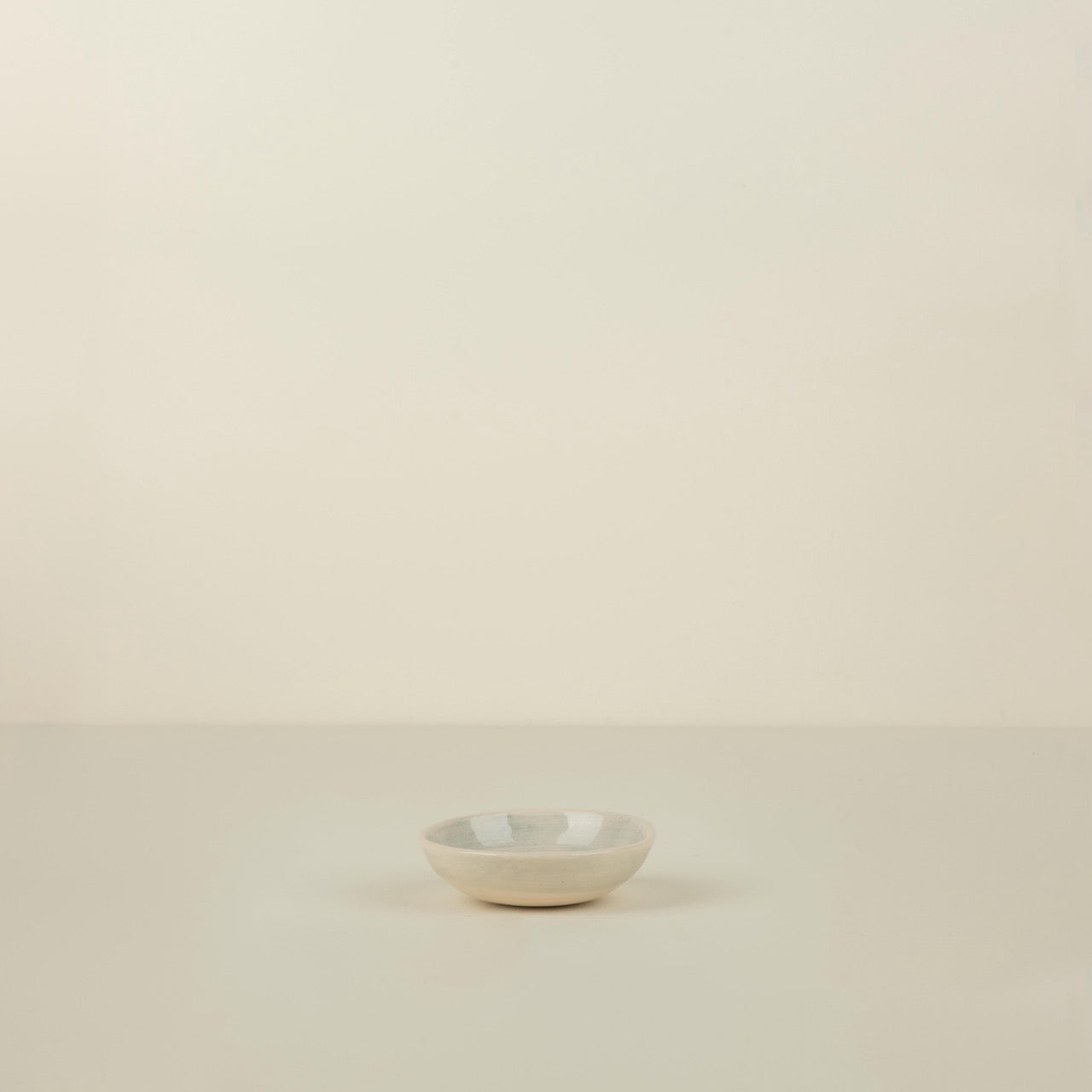 Small white ceramic bowl on a beige background