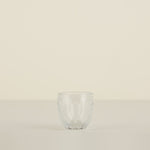 Clear glass tumbler on a beige background