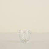 Clear glass tumbler on a beige background