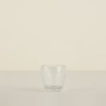 Clear glass tumbler on a beige background