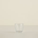 Clear glass tumbler on a beige background