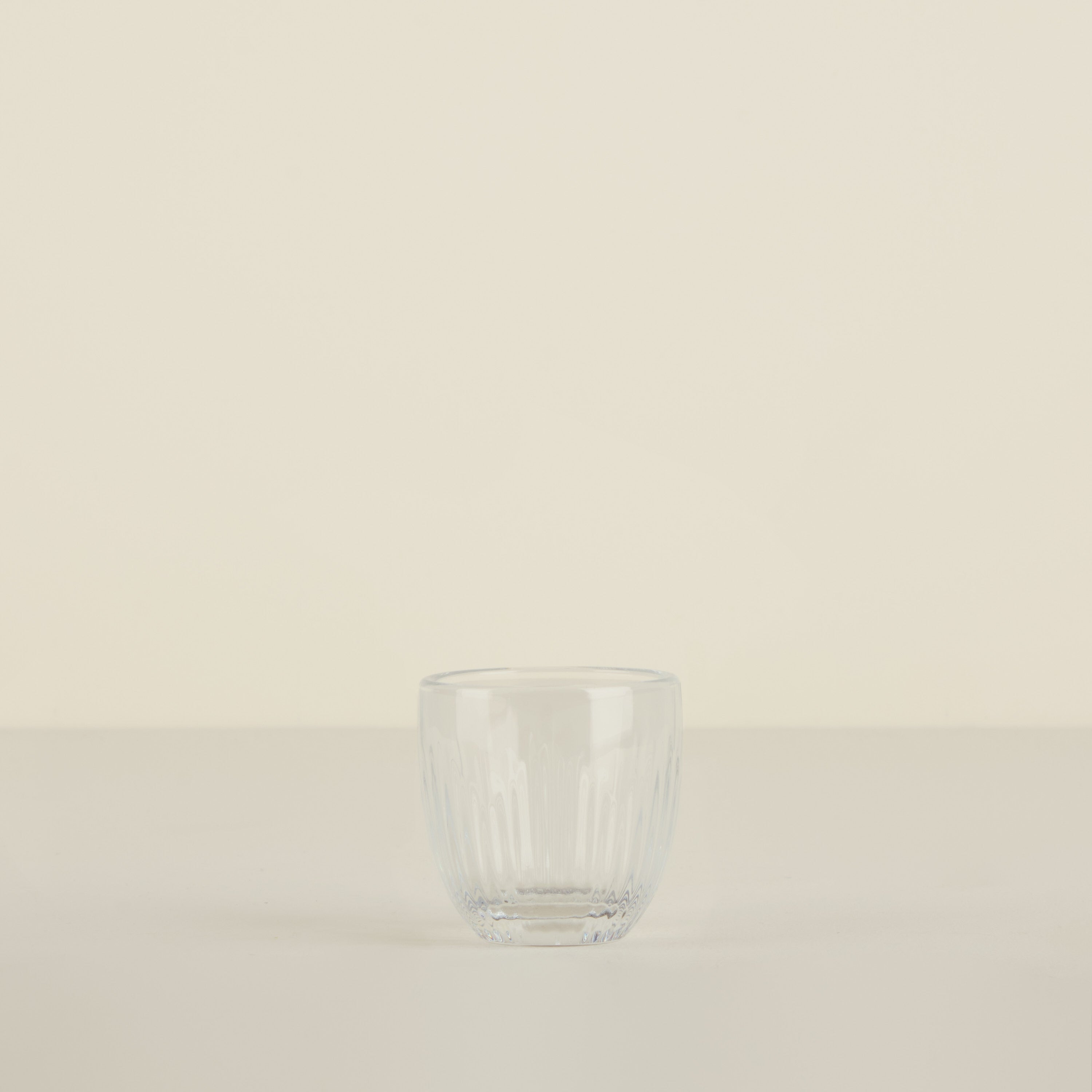 Clear glass tumbler on a beige background