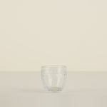 Clear glass tumbler on a beige background