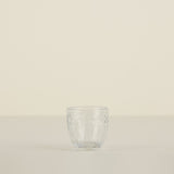 Clear glass tumbler on a beige background