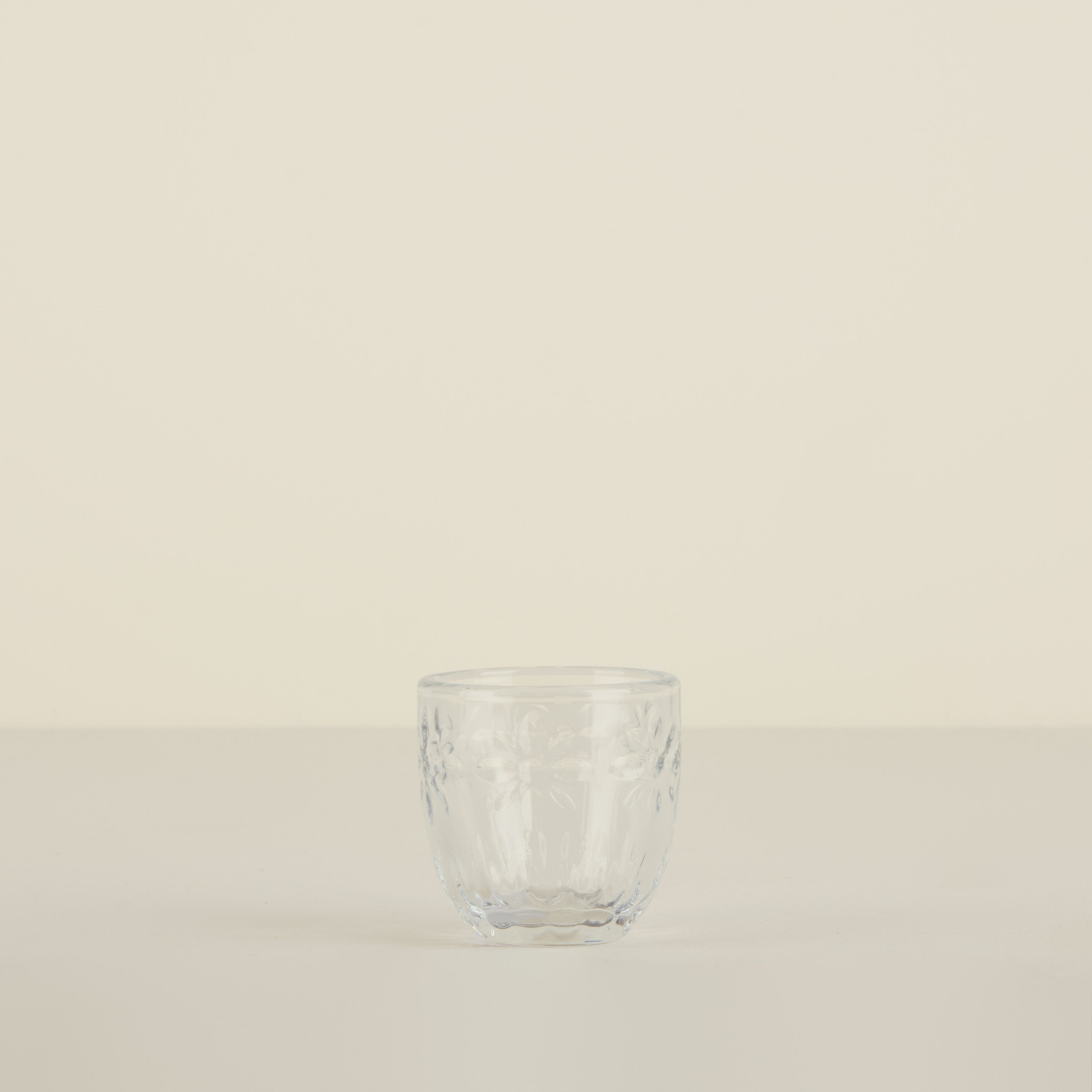 Clear glass tumbler on a beige background