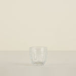 Clear glass tumbler on a beige background