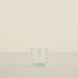 Clear glass tumbler on a beige background