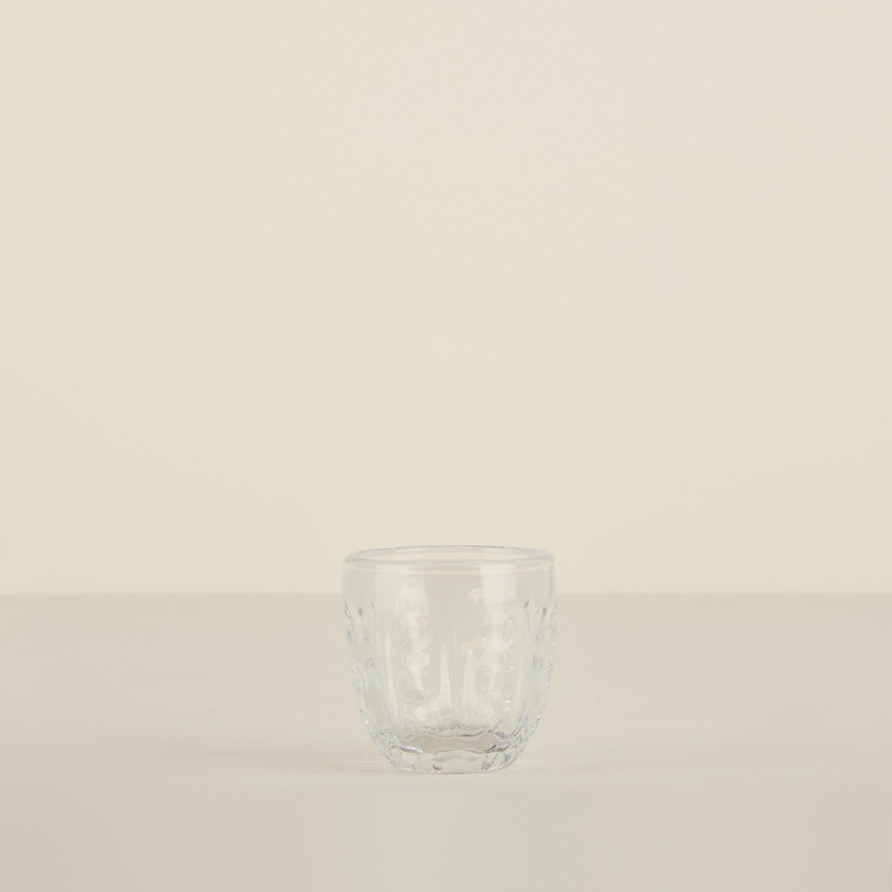 Clear glass tumbler on a beige background